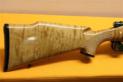 Multiple brass inlays over most areas of the wood stock including, animals, and a Federal style eagle over a shield containing stars and stripes on. . Birds eye maple gun stock